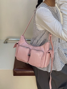 Pink Y2K style glossy shoulder bag with multiple functional zip pockets worn by model