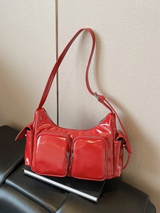 Chic red patent leather shoulder bag with multi-pocket design and metallic zippers