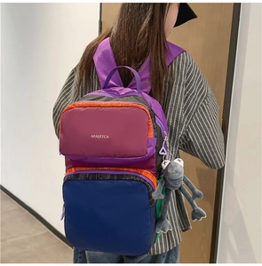 Close-up of a multi-color patchwork backpack with purple, blue, and orange panels