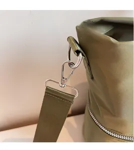 Détail du fermoir mousqueton argenté et de la sangle tissée sur un sac cabas en nylon