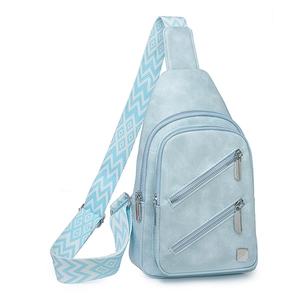 Close-up of light blue crossbody bag with wide geometric pattern strap and metal logo