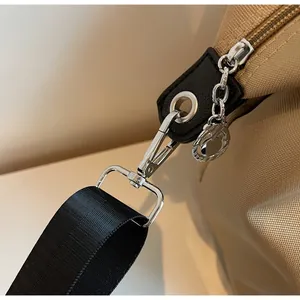 Detail of durable silver swivel hook and leather reinforcement on khaki travel tote bag