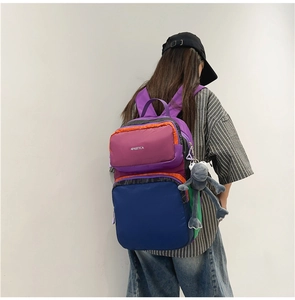 Rear view of colorful patchwork backpack with front zipper pocket and plush frog charm