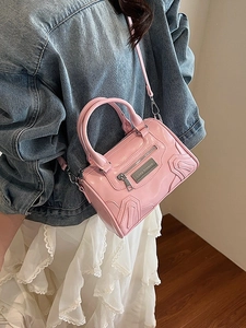 Bolso bandolera rosa brillante con textura ondulada y detalle de logo metálico