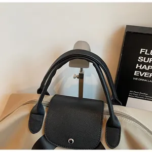 Detail of the durable leather handle and metal buckle on the beige travel tote bag