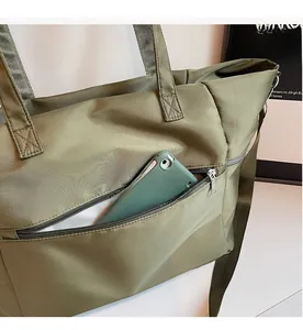 Détail du sac fourre-tout en nylon vert armée avec une poche latérale zippée pratique