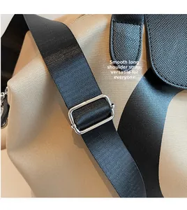 Detail of adjustable black nylon shoulder strap and silver metal buckle on a tote bag