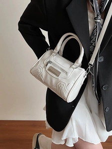 Bolso cilíndrico blanco estilo almohada con correa ajustable en un look elegante minimalista
