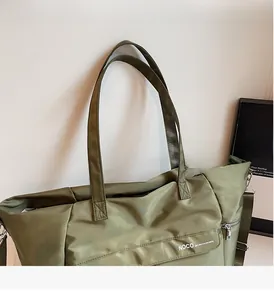 Vue détaillée du sac cabas en nylon vert olive avec poche zippée et logo NOCO