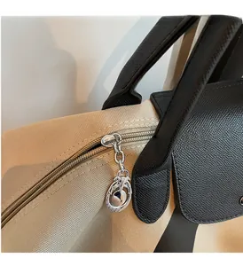 Close-up of premium silver hardware and leather stitching on canvas travel tote bag