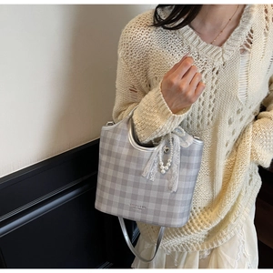 Silver checkered tote bag with lace bow and pearl charm shown on model shoulder