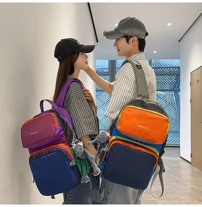 Close-up of stylish color-block backpacks with cute monkey charms for travel and school