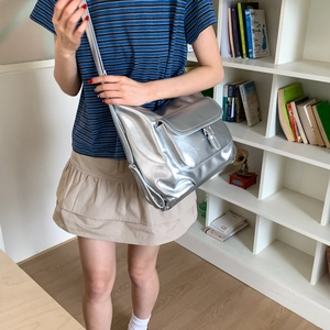 Detailaufnahme einer großen silbernen Metallic-Tasche mit Schnalle und Vordertasche