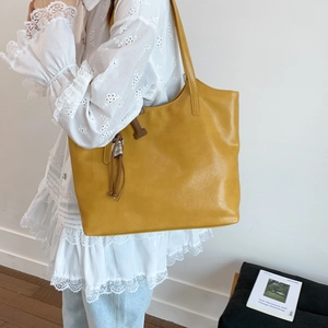 Primer plano de un bolso tote amarillo mostaza en cuero sintético de gran capacidad