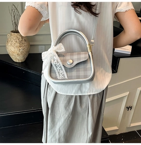 Silver checkered handbag featuring white lace bow detail and metallic silver trim accent