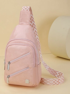 Pink faux leather crossbody chest bag with decorative wide geometric patterned shoulder strap