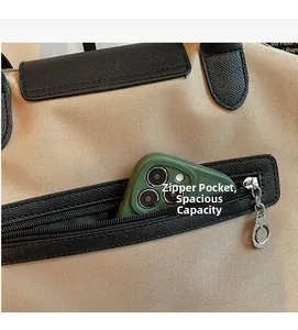 Detail of canvas tote bag showing large front zipper pocket with phone storage space