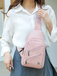 Pink PU leather crossbody chest bag for women with wide geometric pattern strap on model