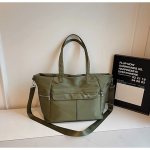Détail du fourre-tout en nylon vert armée avec logo NOCO et poche à fermeture éclair