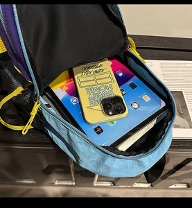 Detail view of large capacity color-block nylon backpack showing interior storage and tablet