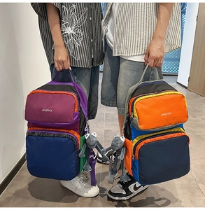 Detailed view of large capacity nylon backpacks with frog charms and multi-pocket design