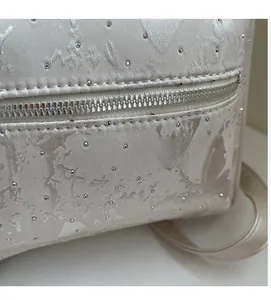 Macro detail of satin jacquard fabric with floral patterns and silver rhinestones