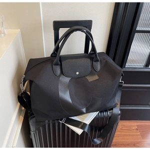 Detail of black travel bag with leather handles on a suitcase for business trips