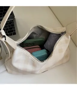 Vue de dessus montrant l'intérieur spacieux du sac à bandoulière beige à carreaux