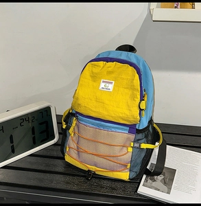Close-up of lightweight nylon backpack with blue and yellow contrast and bungee cords