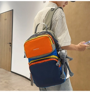 Detail of multi-color backpack with blue and orange contrast and plush frog accessory