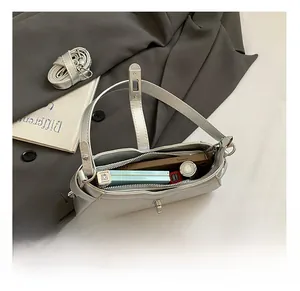 Silver baguette bag detail showing spacious interior with zipper pocket and metal lock
