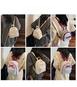 Detail view of mini bow backpack in lace and plaid patterns worn on a model