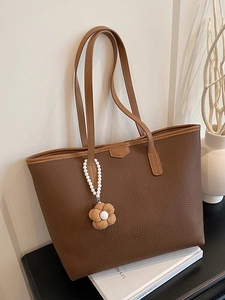 Sac fourre-tout minimaliste marron à motif litchi avec pendentif fleur sur blanc