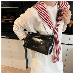 Detail of black glossy crossbody bag with silver chain strap and CLEAROK logo