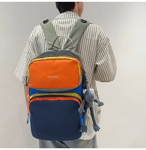 Detail of multi-color casual backpack with brand logo and cute frog plush pendant