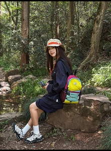 Outdoor view of multi-color patchwork backpack with bungee cord for travel and hiking