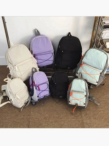 Detail view of lightweight nylon backpack showing the colorful bungee cord and zipper pockets