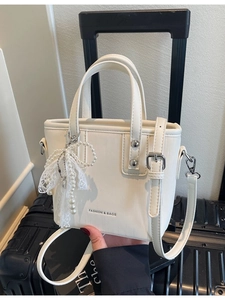 White mini tote bag with pearl lace bow charm and adjustable shoulder strap for women