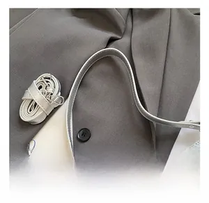 Detail view of silver baguette bag with metallic buckle and detachable shoulder strap