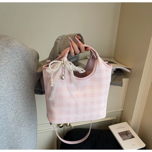 Detail of pink plaid tote bag with pearl bow pendant and silver heart charm