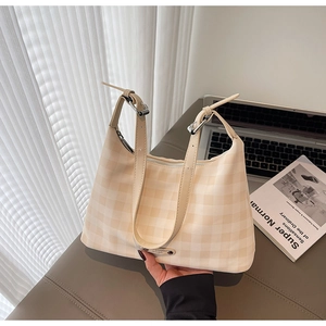 Détail du sac hobo à carreaux beige avec bretelles réglables et plaque en métal dorée