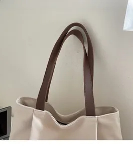 Detail of sturdy canvas tote bag with reinforced brown faux leather shoulder straps