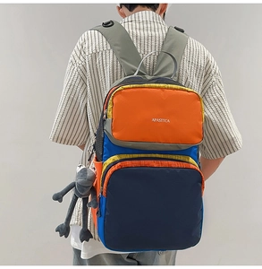 Outdoor multi-color patchwork backpack with brand lettering and gray plush pendant