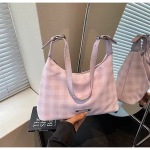 Détail du sac baguette à carreaux lilas avec bandoulière réglable et logo métal