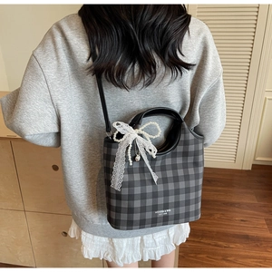 Detail of grey plaid tote bag with white lace pearl bow and thin shoulder strap