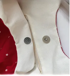 Détail de la doublure florale, du fermoir magnétique et du zip sur le sac en toile
