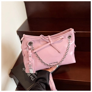 Dettaglio borsa rosa in pelle PU con fiocco, catena argento e lucchetto sulle scale