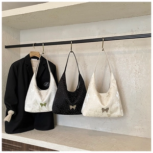 Détail de trois sacs portés épaule en croissant avec décoration nœud sur cintres
