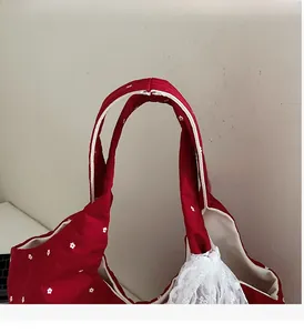 Détails de la poignée du sac fourre-tout à fleurs rouges avec bordure en dentelle