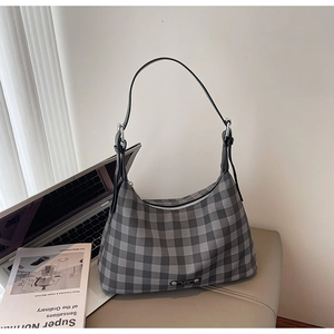 Détails d'un sac bandoulière à carreaux avec fermeture éclair en métal et sangle en cuir